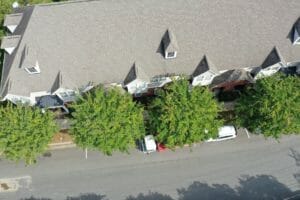 An aerial view of a row of houses with cars parked in front of them.